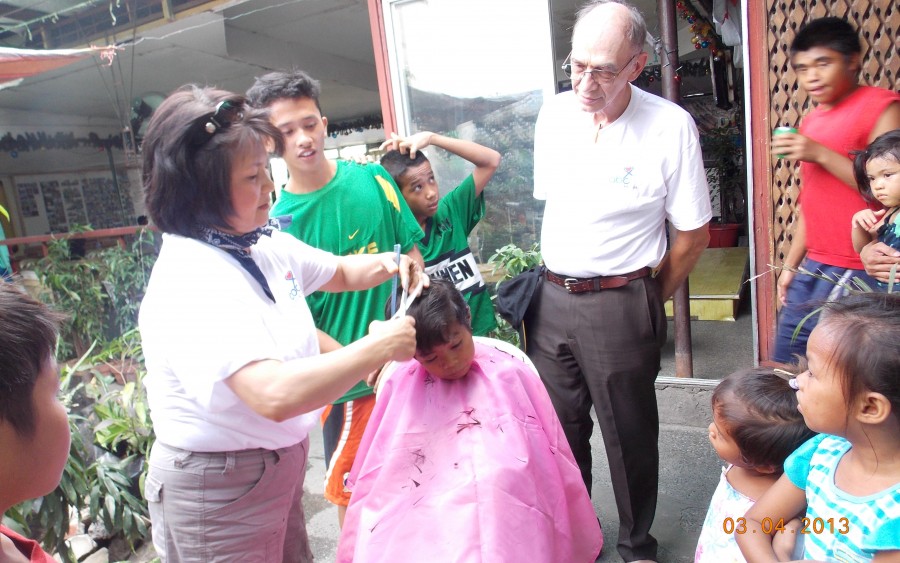 Kim Demars from Florida, USA gives a haircut to one of the children in a project in the Philippines